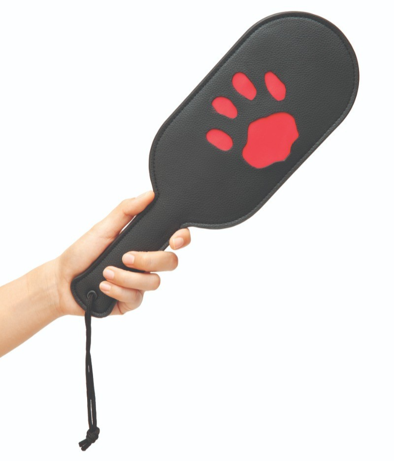 Black paddle with red paw print held by a hand on a white background