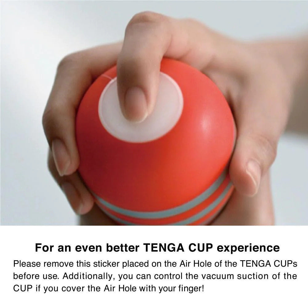 Hand holding a red Tenga cup with text on a white background