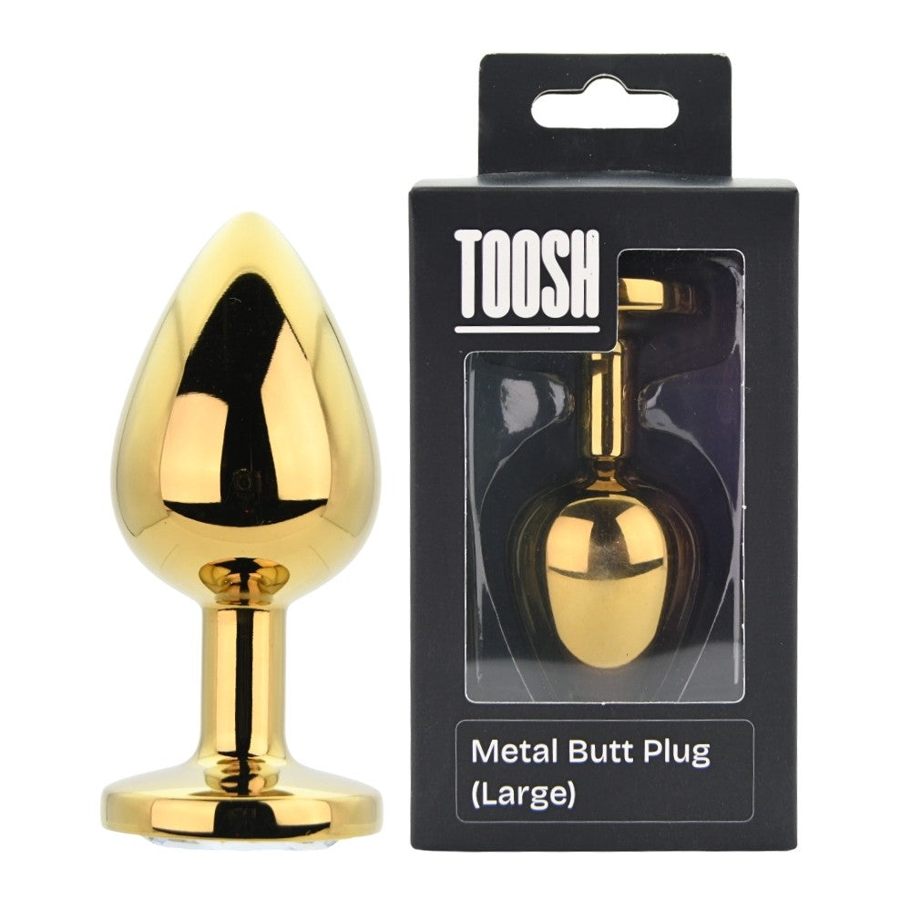 Gold metal butt plug with packaging labeled 'TOOSH' on a white background