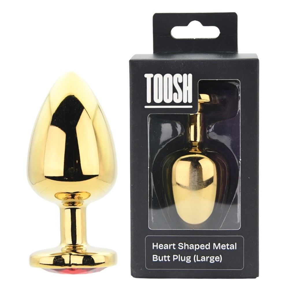 Gold heart-shaped metal butt plug in packaging with 'TOOSH' branding on a white background.