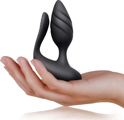 Black silicone butt plug held in a hand on a white background