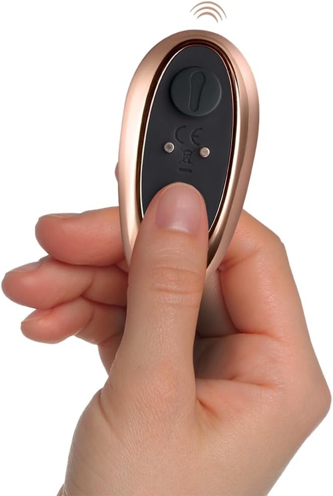 Rose gold remote control held in a hand with a white background