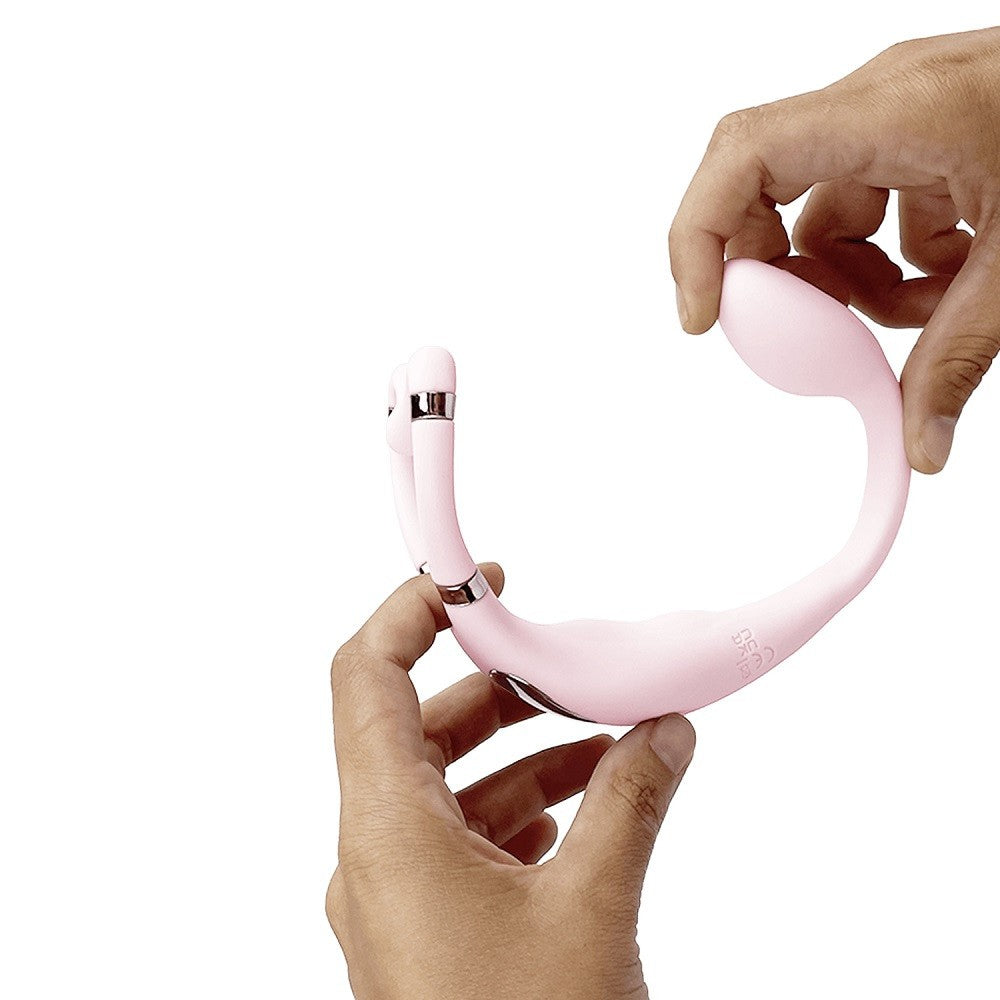Pink sex toy held by hands on a white background