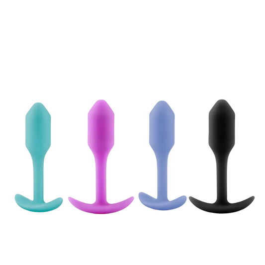 Four silicone butt plugs in different colors on a white background