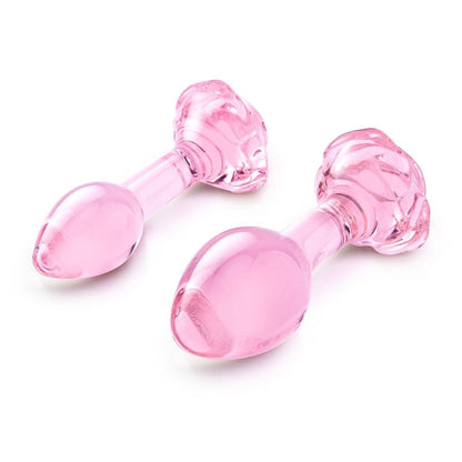 Two pink rose glass butt plugs on a white background