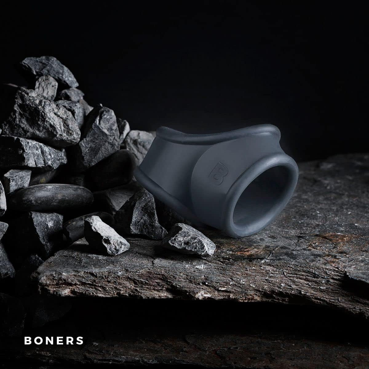 Gray silicone product on a dark background with rocks