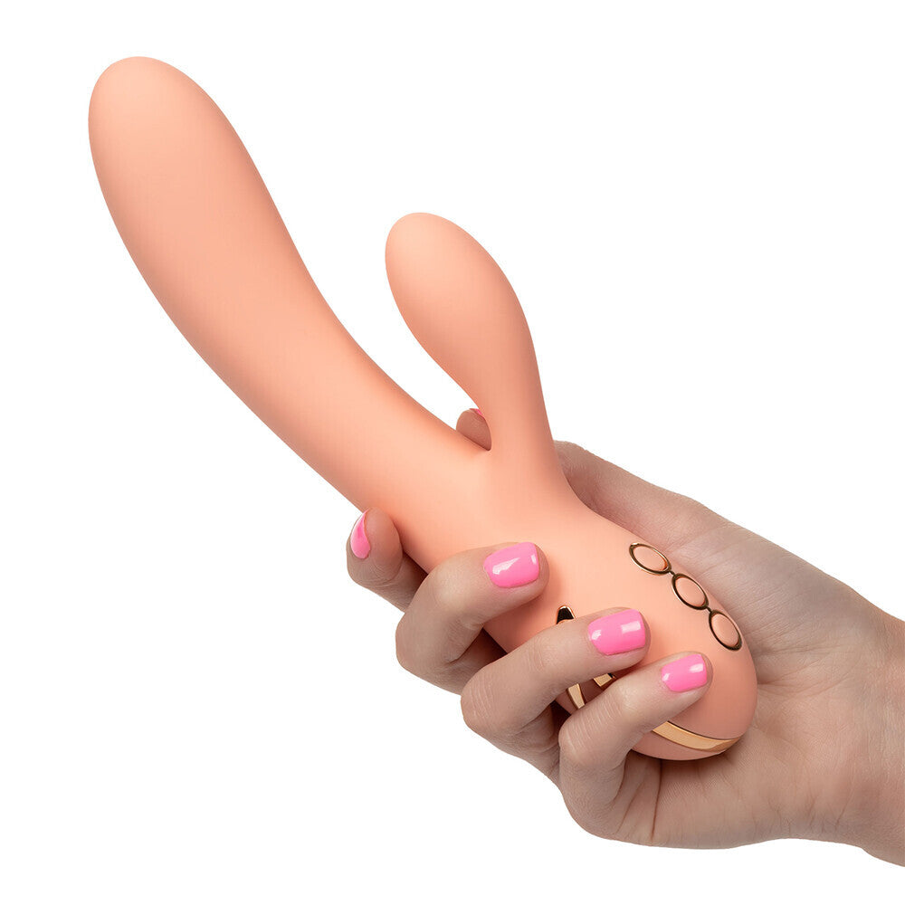 Hand holding a peach-colored sex toy with a white background