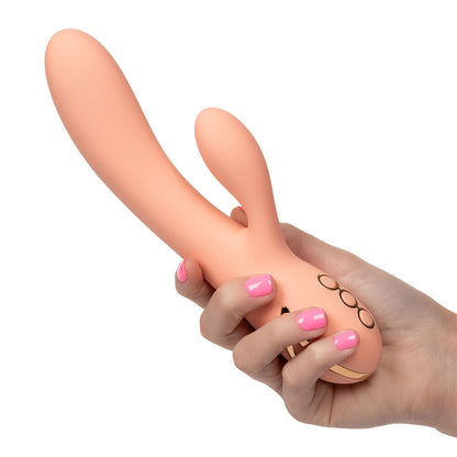 Hand holding a peach-colored sex toy with a white background