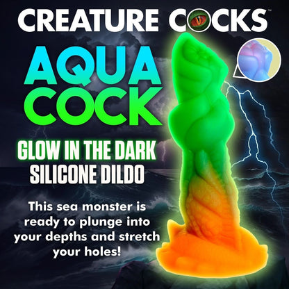 Glowing silicone dildo with text 'Creature Cocks Aqua Cock' on a dark background