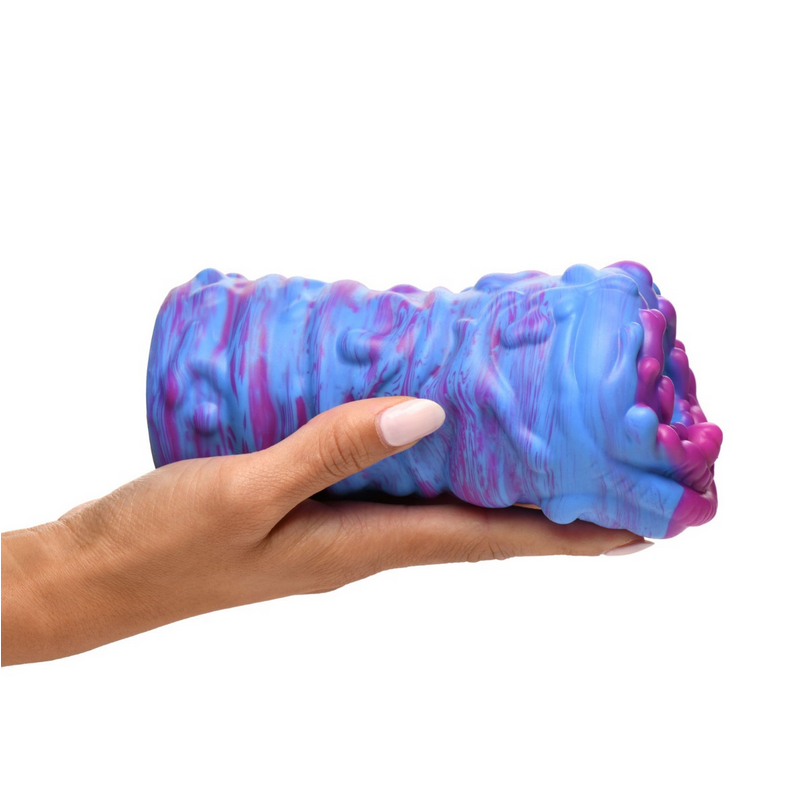 Hand holding a blue and pink textured object against a white background