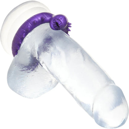 Clear dildo with purple cock ring on a white background