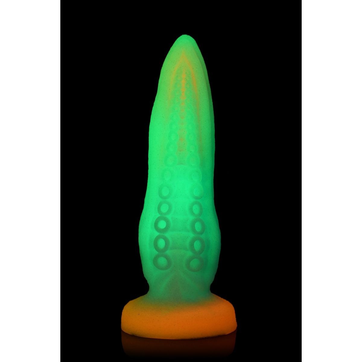 Glowing green and orange object on a black background