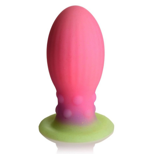 Pink and green silicone butt plug on a white background