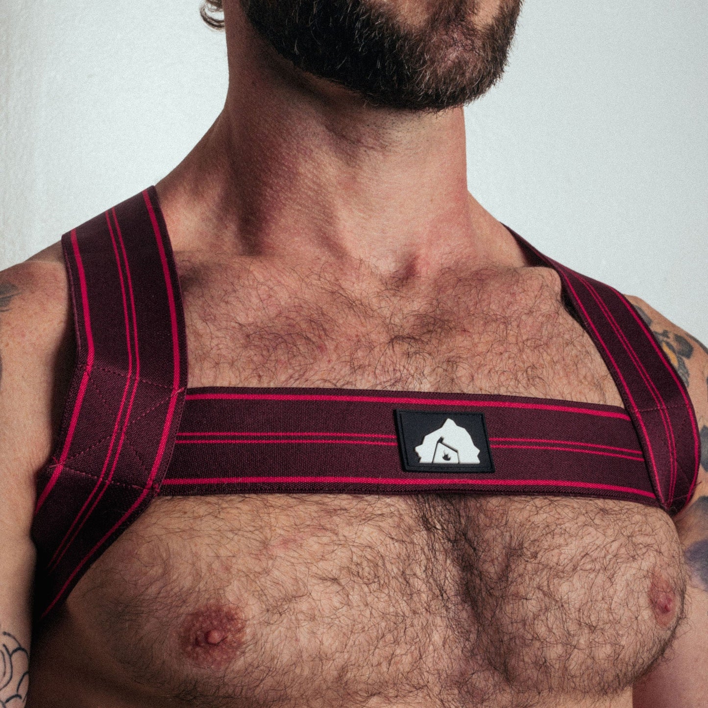 Man wearing a red and black shoulder support brace against a white background