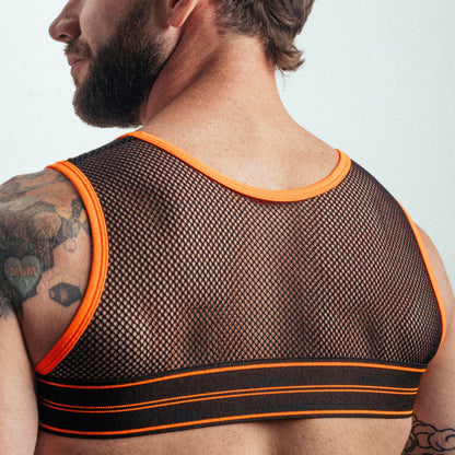 Man wearing a mesh tank top with orange trim on a plain background