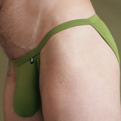 Green men's underwear being worn against a neutral background