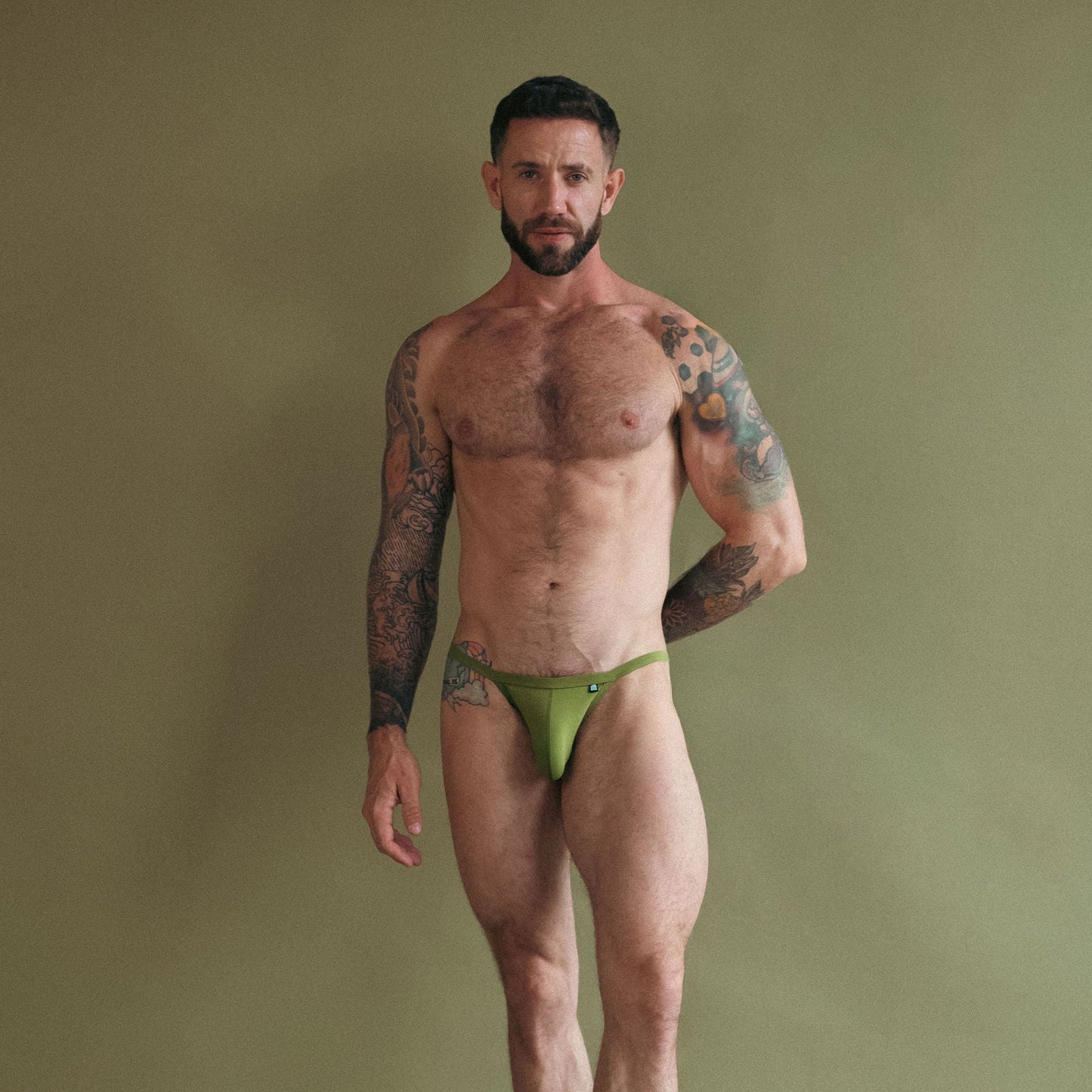 Man wearing green underwear against a plain background