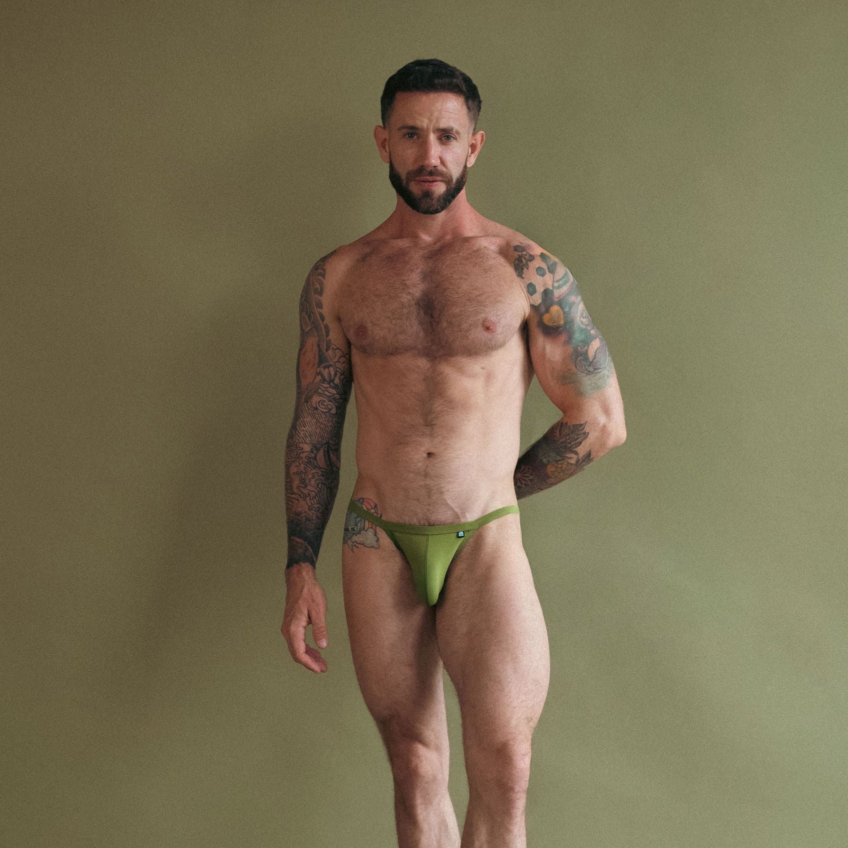 Man wearing green underwear against a plain background