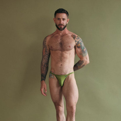 Man wearing green underwear against a plain background