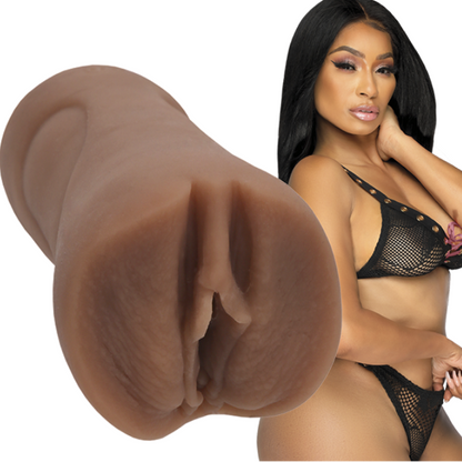 Close-up of a realistic silicone stroker with a model wearing black lingerie in the background.