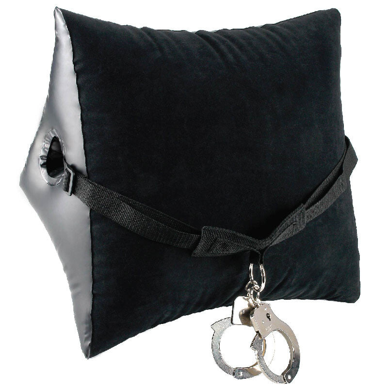 Black pillow with a silver handcuff keychain on a white background