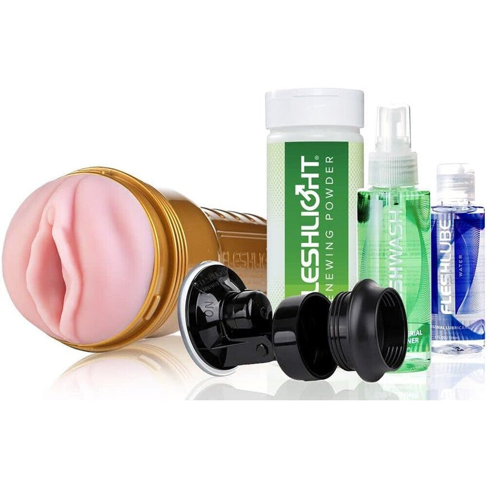 Collection of Fleshlight products including a pink silicone sleeve, black silicone sleeve, and cleaning products on a white background.