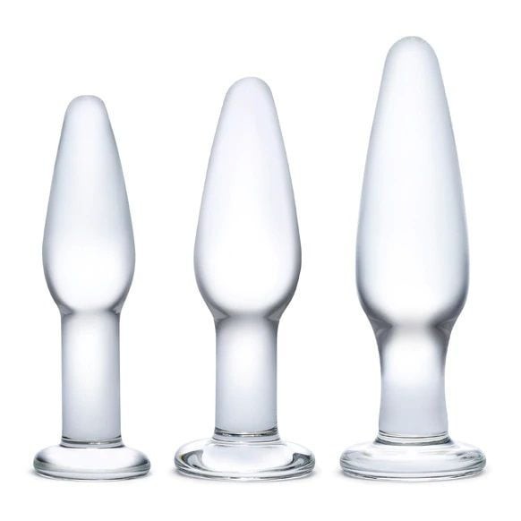 Three clear glass butt plugs of different sizes on a white background