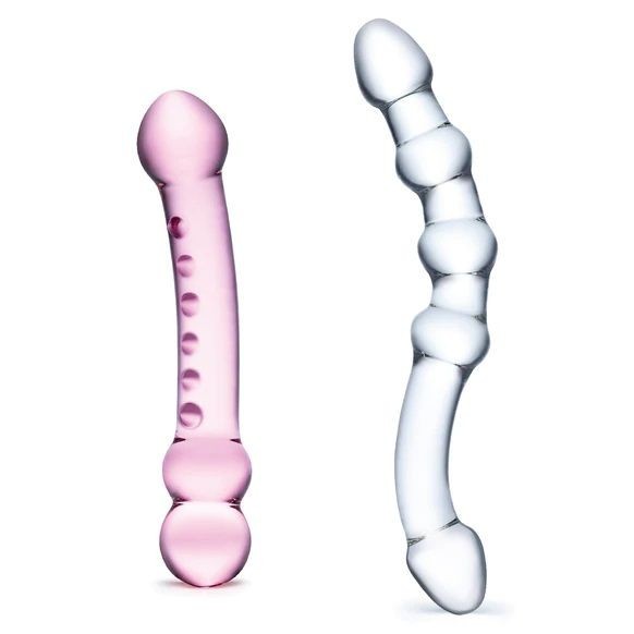 Pink and clear glass massage tools on a white background