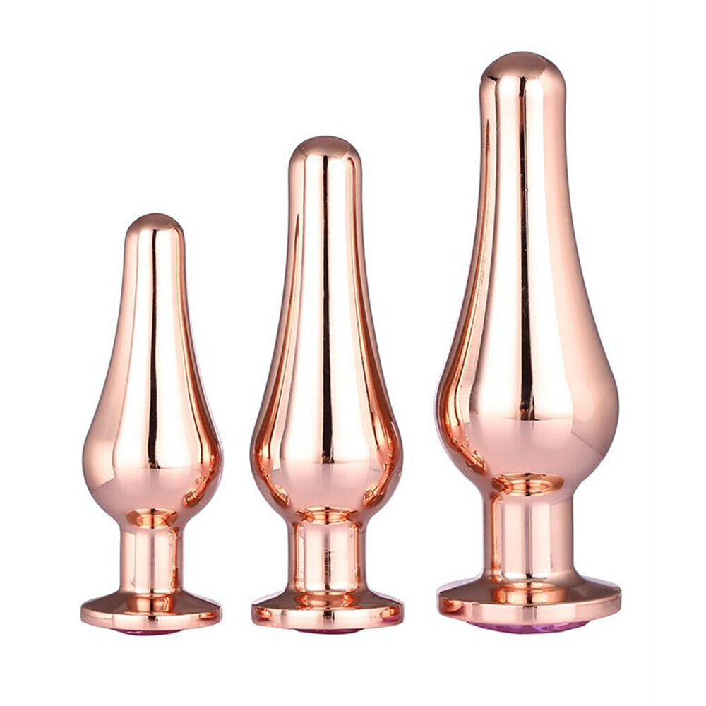 Three rose gold butt plugs of different sizes on a white background