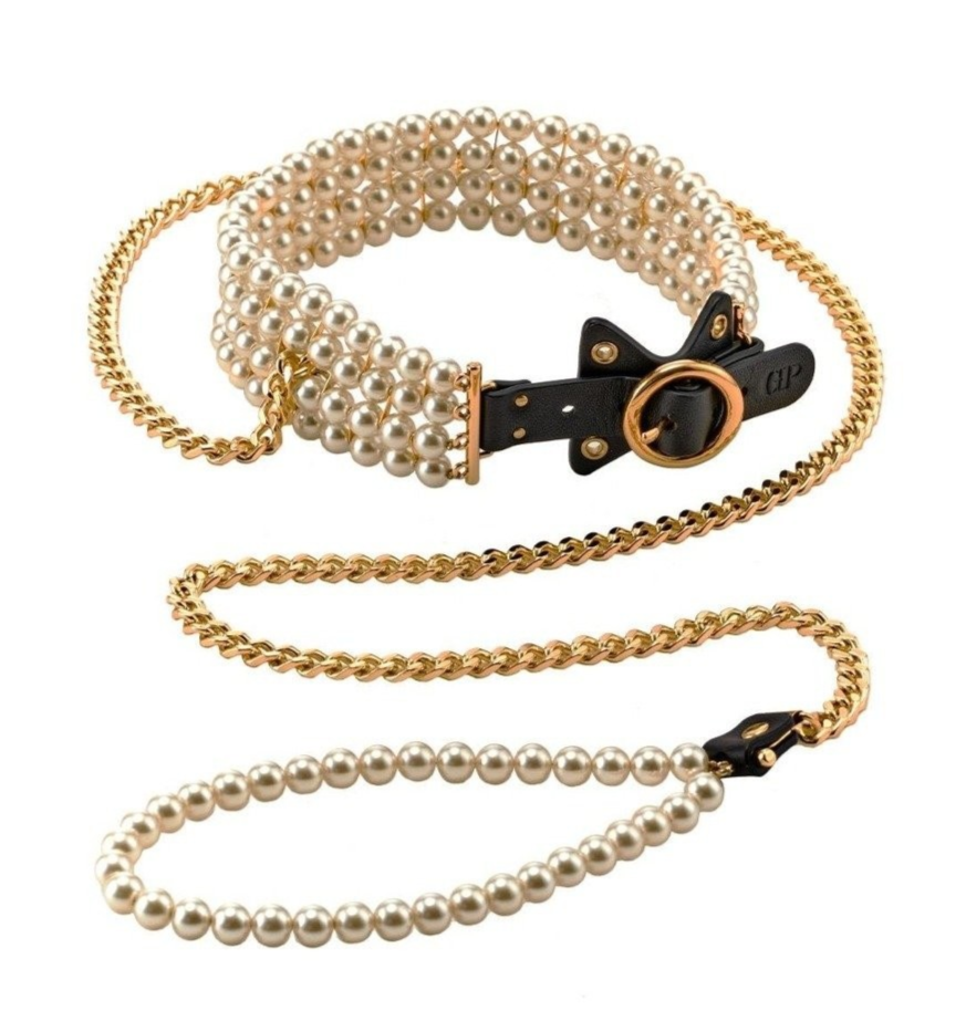 Pearl collar and leash with black leather and gold chain ends on a white background