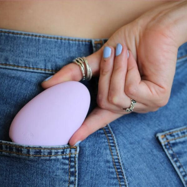Person holding a purple vibrating egg in their jeans pocket