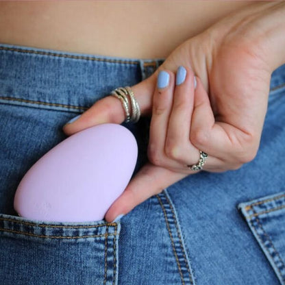 Person holding a purple vibrating egg in their jeans pocket