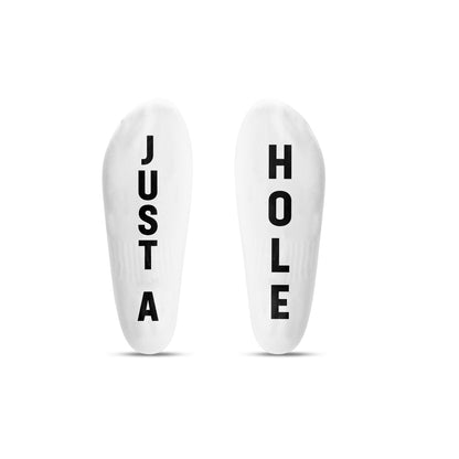 Two white socks with text 'JUST A' and 'HOLE' on a white background
