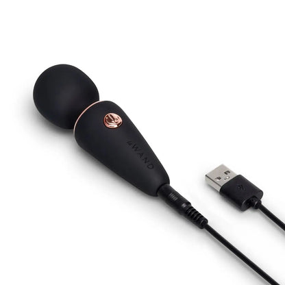 Black and rose gold massage device with USB cable on a white background