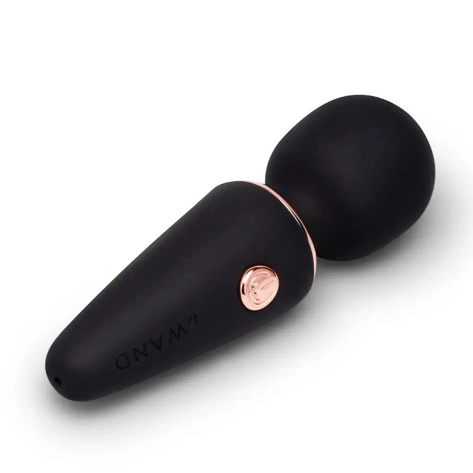 Black and rose gold electronic massager device on a white background