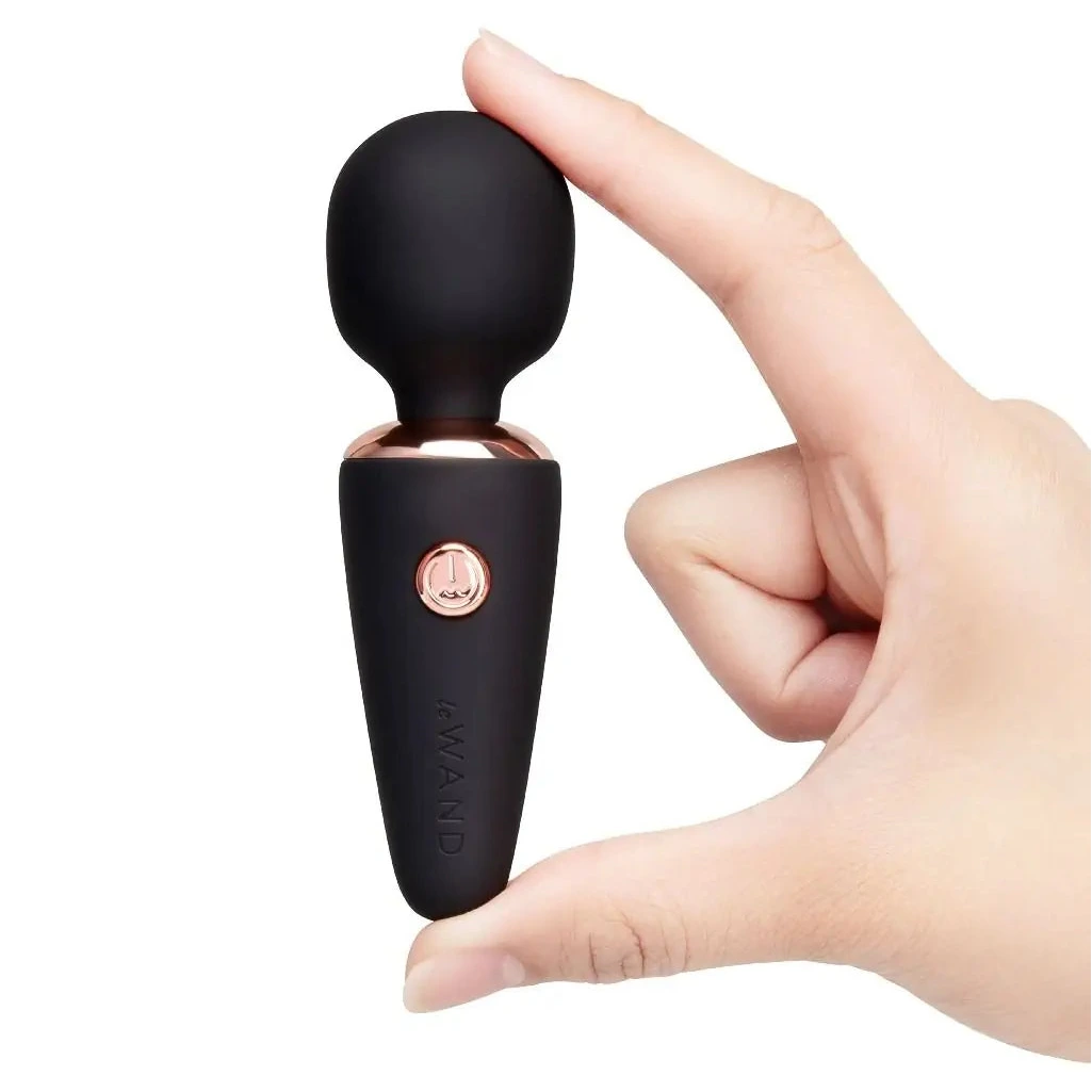 Black and rose gold le wand massager product held in a hand against a white background