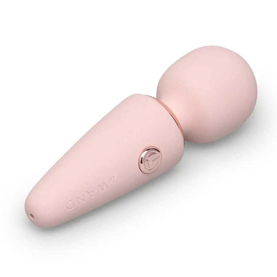 Pink handheld electronic vibrating massager device on a white background