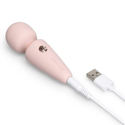 Pink electronic massage device with USB cable on a white background