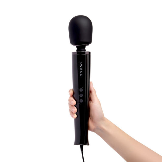 Black handheld device labeled 'le WAND' held by a hand on a white background