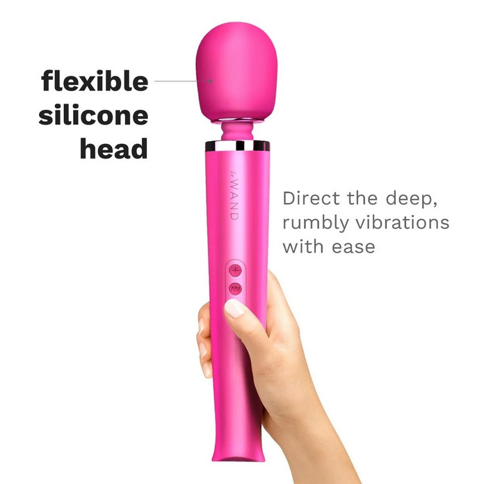 Pink handheld electronic device with a flexible silicone head, held by a hand on a white background.