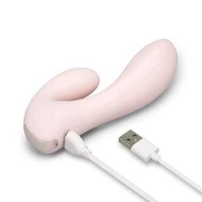 Pink electronic massage device with USB cable on a white background