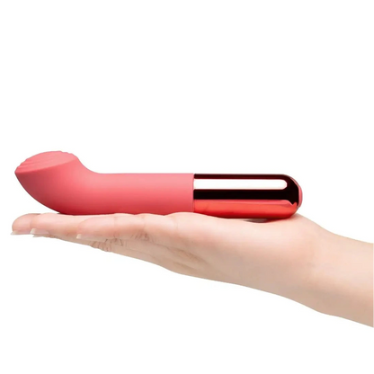 Red and gold cylindrical vibrator held in a hand on a white background