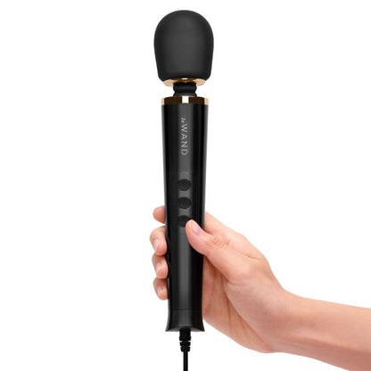 Black handheld device with 'Le WAND' branding held in a hand against a white background