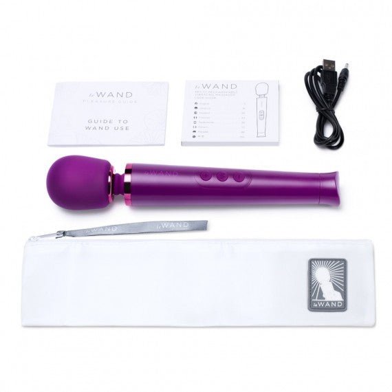 Purple handheld device with packaging, user guide, and cable on a white background