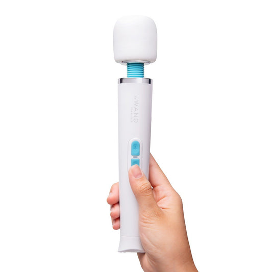 Hand holding a white electronic massage wand with a blue accent on a white background