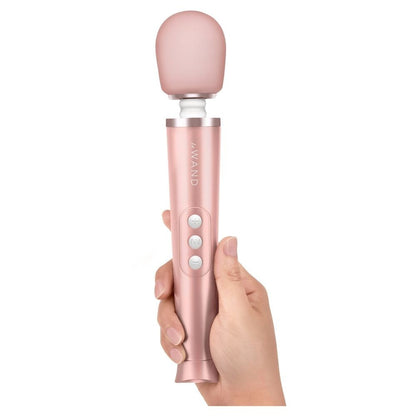 Pink handheld massager held in a hand against a white background
