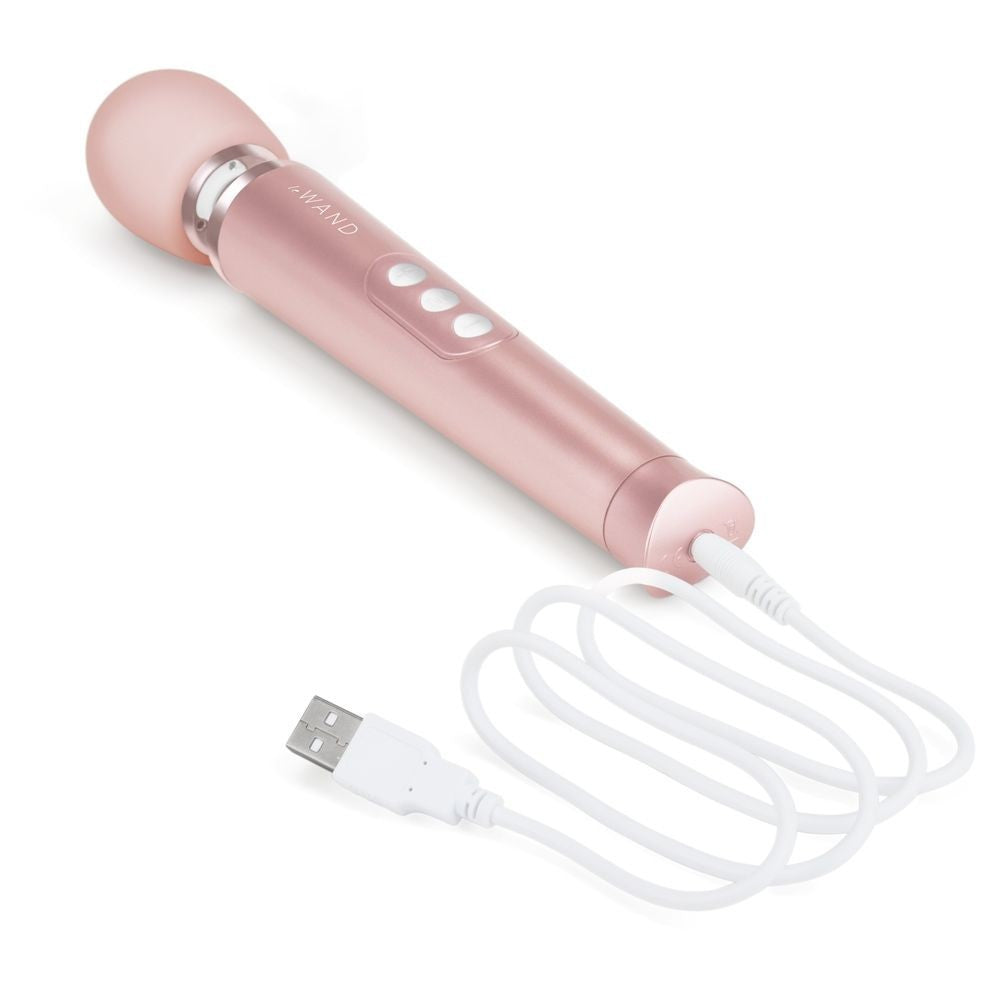 Rose gold handheld device with USB cable on a white background