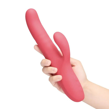 Red silicone rabbit-shaped massager held by a hand on a white background