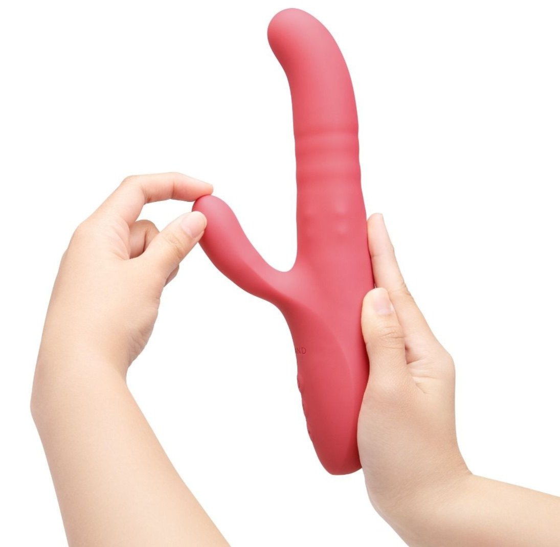 Pink Y-shaped vibrator held by two hands against a white background