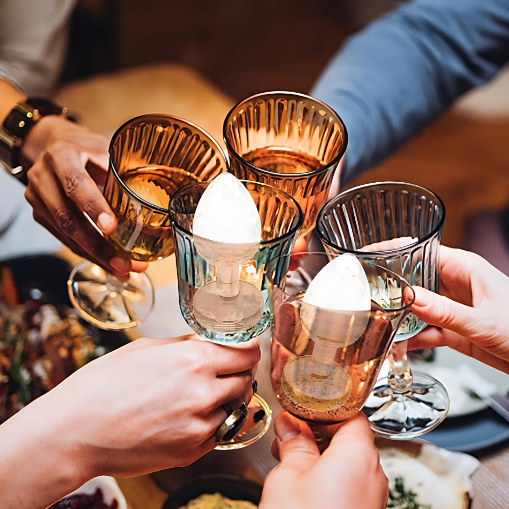 People toasting with amber-colored glasses at a social gathering.
